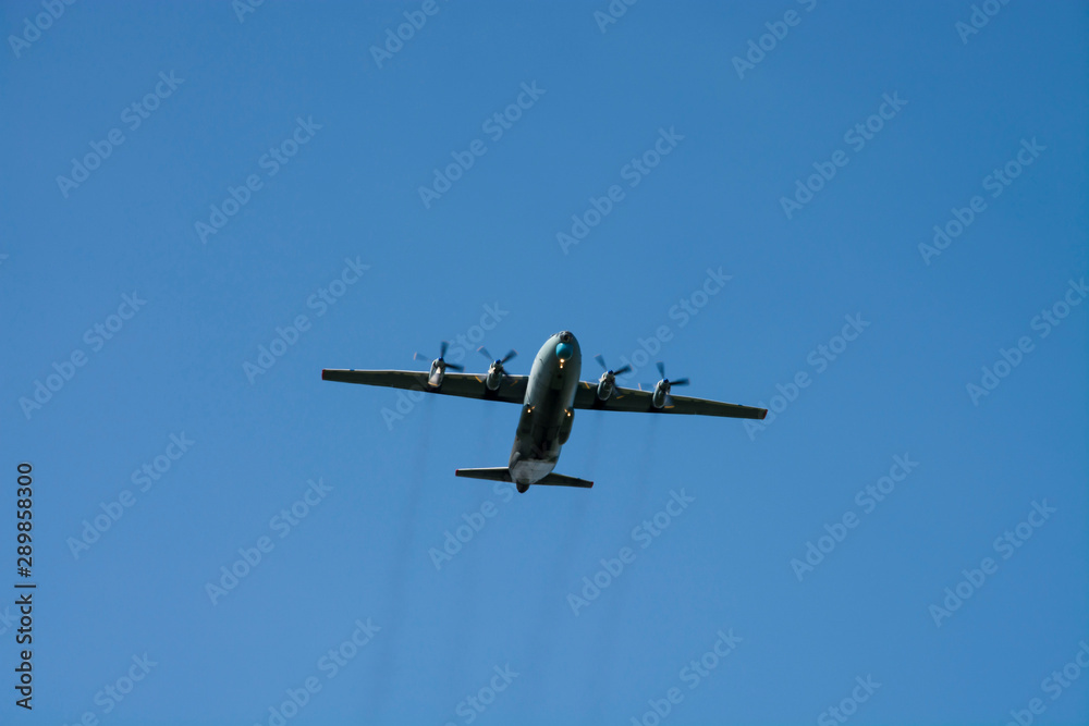 gray military plane flies in the blue sky Peaceful flight demonstration. Day of the city. Memory gray military plane flies in the blue sky Peaceful flight demonstration. Day of the city. Memory