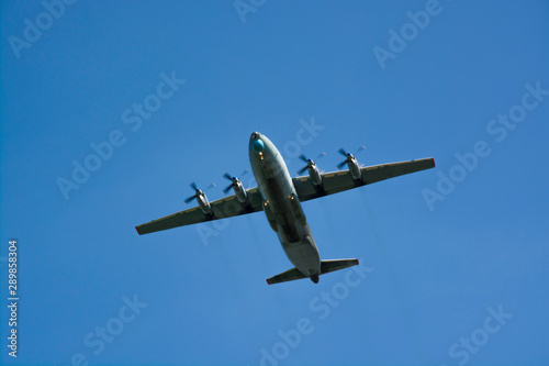 gray military plane flies in the blue sky Peaceful flight demonstration. Memory. Day of the city.. Air show