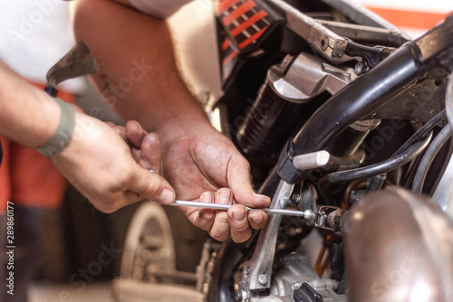 Mechanic Repairing A Motorbike Engine In A Workshop .
