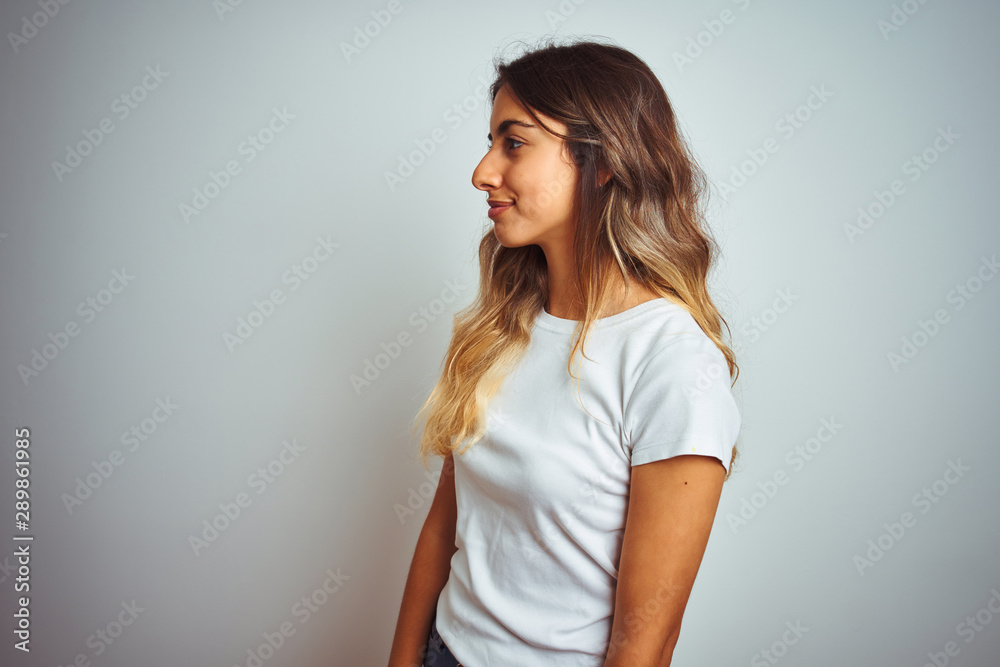 Young beautiful woman wearing casual white t-shirt over isolated background  looking to side, relax profile pose with natural face and confident smile.  Stock Photo | Adobe Stock