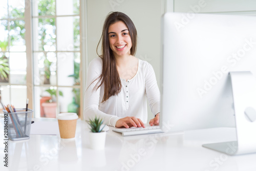 Free Download Beautiful young business woman working using computer, smiling and concentrated on online work - GFXLoad