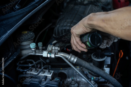 Auto mechanic changing oil machine.The man is changing the motor oil.Change engine oil.Replacement of automobile oil.Check the auto maintenance.transportation repair service center