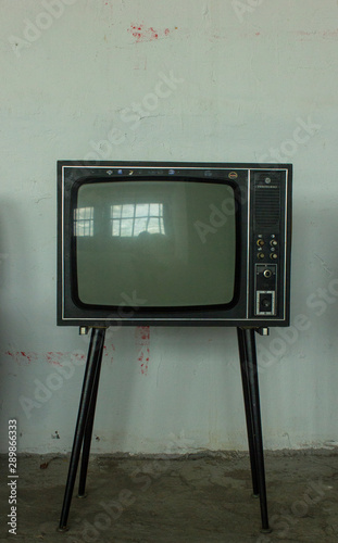 Old Television with 4 legs in the corner of vintage room