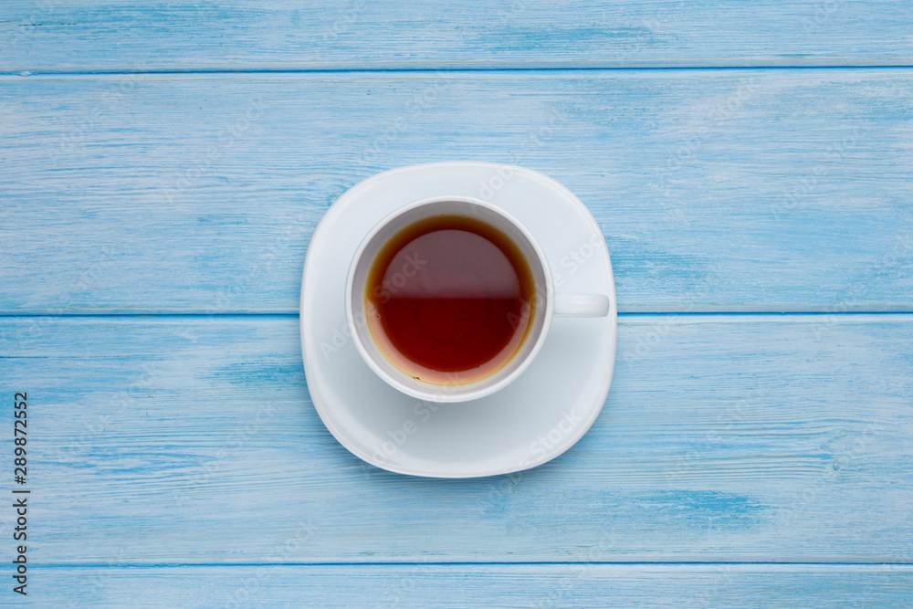 Obraz premium Top view cup of tea on blue wooden table