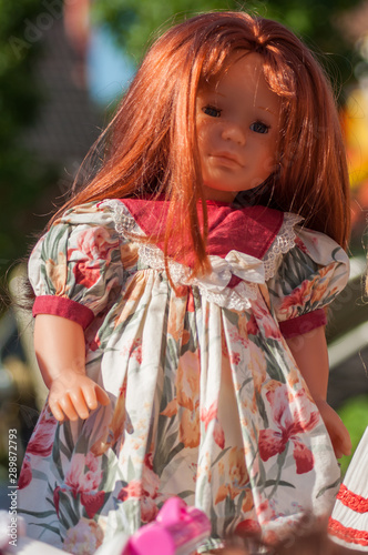 Closeup of vintage dolls with red hairs and beautiful dress at flea market in the street © pixarno