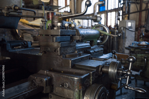 Rusty mechanisms and tools in the shop of an old abandoned factory.