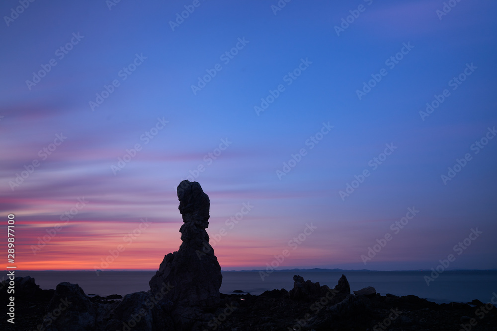 a sunset rock by the seashore