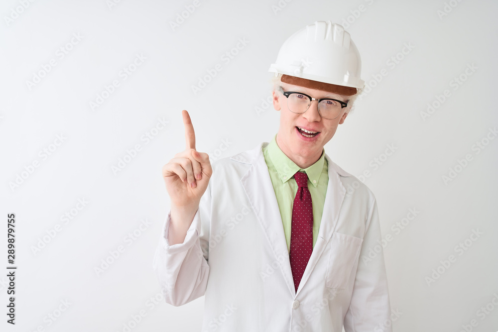 Albino scientist man wearing glasses and helmet standing over isolated white background pointing finger up with successful idea. Exited and happy. Number one. Albino scientist man wearing glasses and helmet standing over isolated white background pointing finger up with successful idea. Exited and happy. Number one.