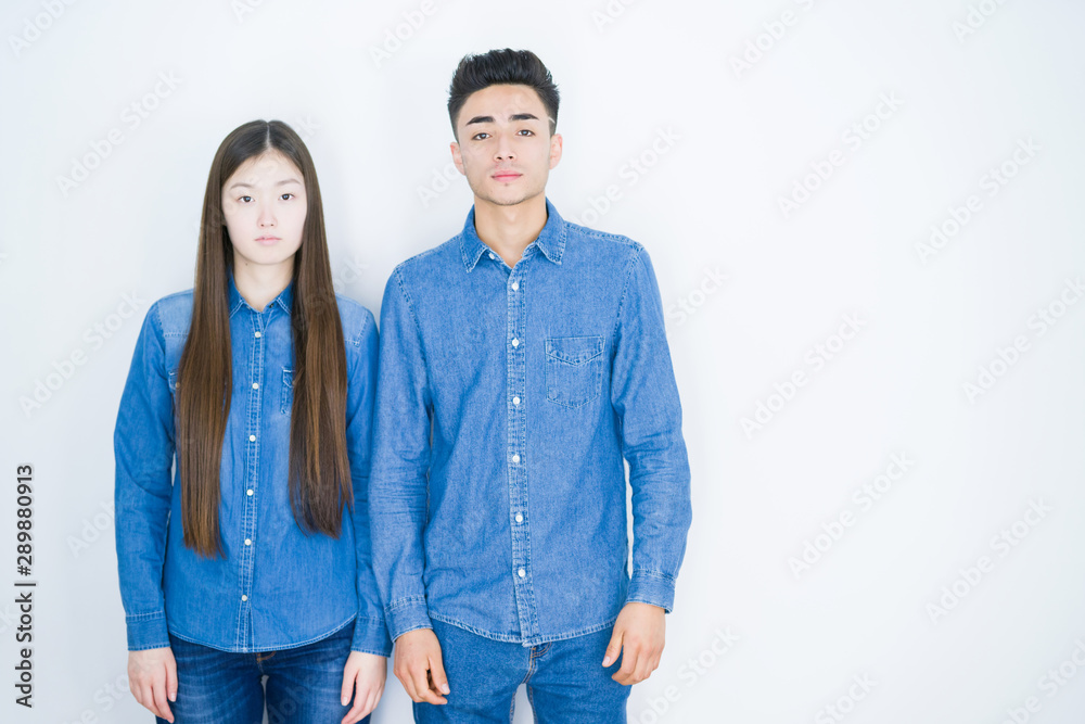 Beautiful young asian couple over white isolated background Relaxed with serious expression on face. Simple and natural looking at the camera. Beautiful young asian couple over white isolated background Relaxed with serious expression on face. Simple and natural looking at the camera.