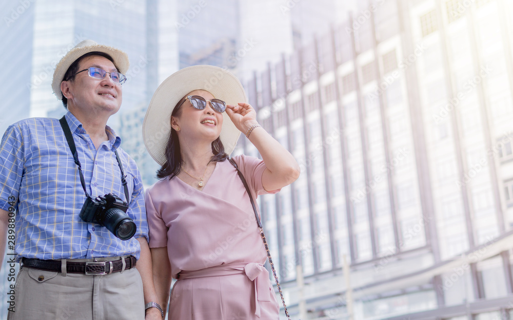 Senior Asian tourists couple sightseeing in downtown Bangkok.