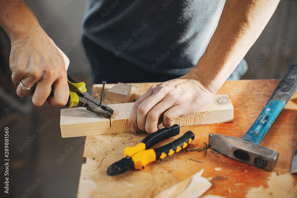 A man carves a tree. The carpenter works with pliers in a studio. An engineer provides a tree shape A man carves a tree. The carpenter works with pliers in a studio. An engineer provides a tree shape