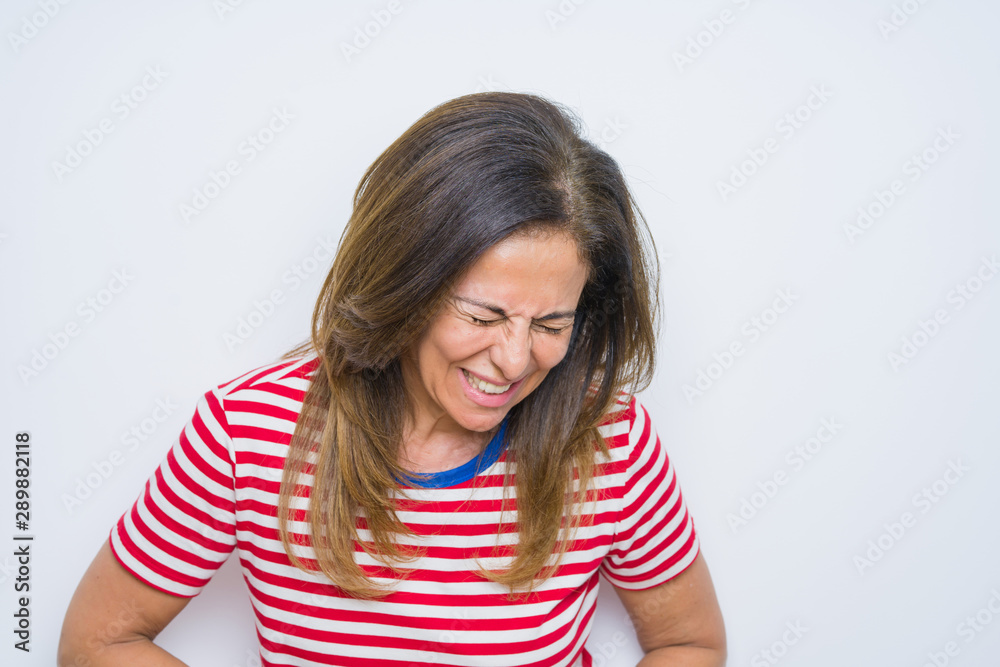 Middle age senior woman standing over white isolated background with hand on stomach because nausea, painful disease feeling unwell. Ache concept. Middle age senior woman standing over white isolated background with hand on stomach because nausea, painful disease feeling unwell. Ache concept.