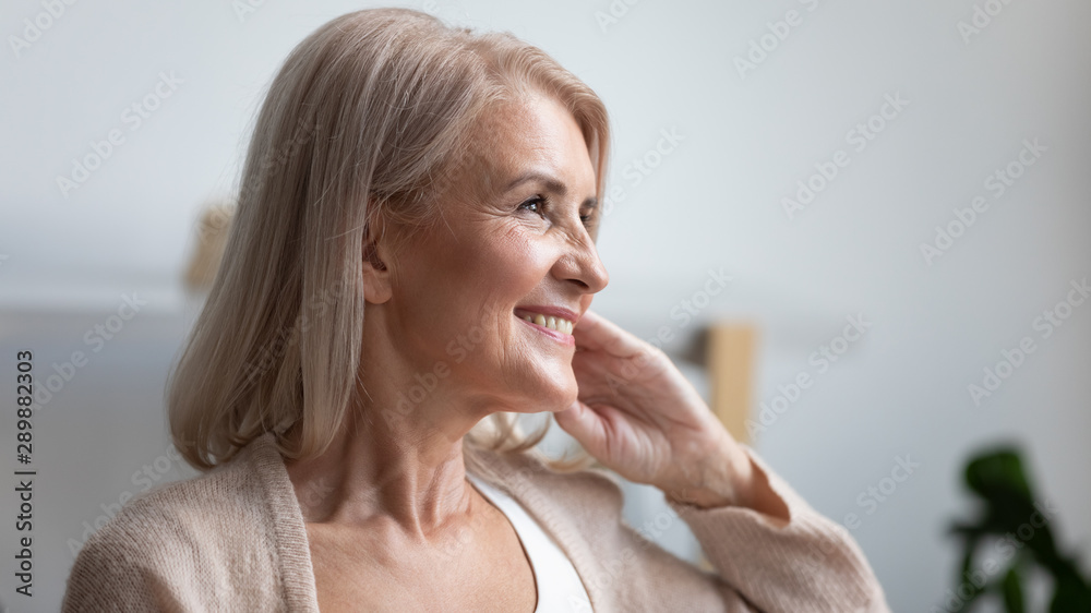 Close up profile smiling mature woman dreaming about good future