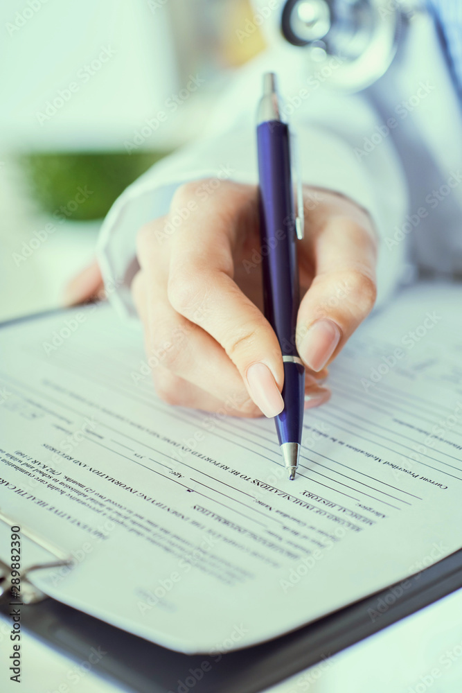 Female doctor hand hold silver pen filling patient history list at clipboard pad. Panacea and life save, prescribing treatment. Female doctor hand hold silver pen filling patient history list at clipboard pad. Panacea and life save, prescribing treatment.