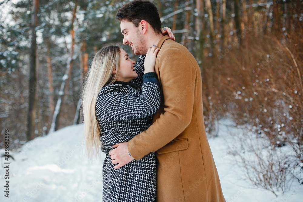 happy young couple walking through the park on a snowy day happy young couple walking through the park on a snowy day