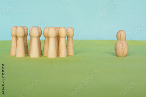 group of little figurines standing opposite to a single, different looking figurine
