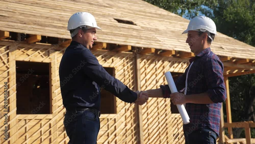 teamwork handshake. concept building constructing architect slow motion video. two men builder in helmets shake hands contract business contrast at a construction site. two workers in helmets shaking teamwork handshake. concept building constructing architect slow motion video. two men builder in helmets shake hands contract business contrast at a construction site. two workers in helmets shaking