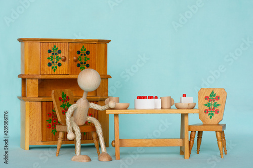 figurine sitting alone in a dinig room with a table set for two