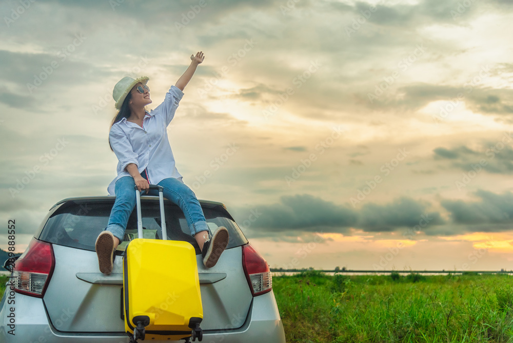Side view of woman traveler standing with hatchback car against the sunset sky background. Side view of woman traveler standing with hatchback car against the sunset sky background.