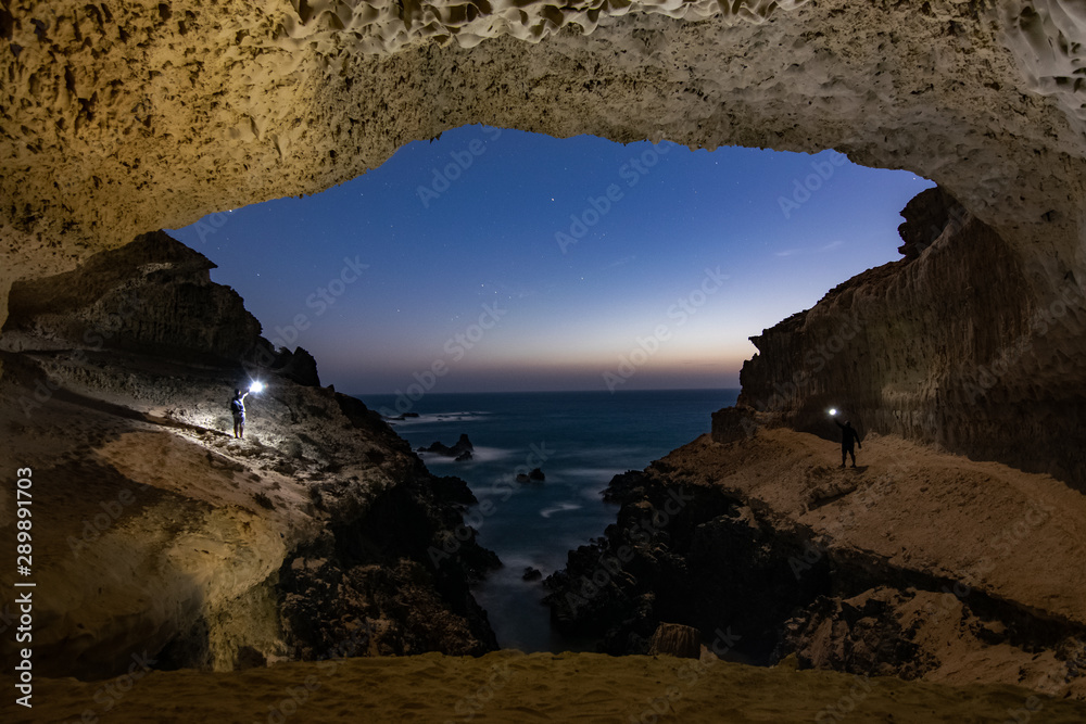Cueva maravillosa con dos persona iluminando la noche