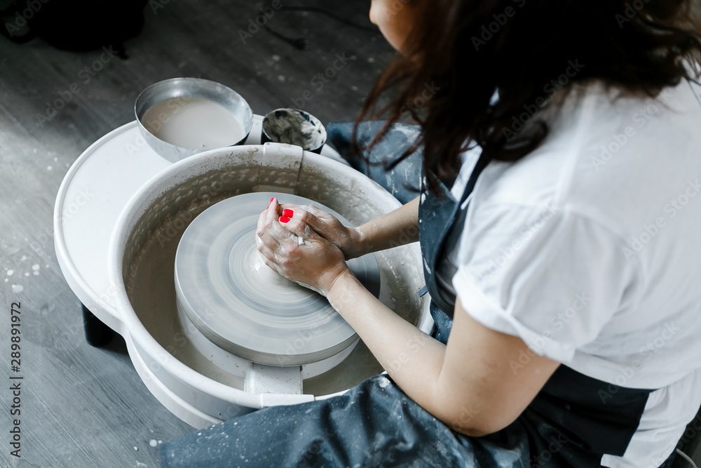 girl makes a product on a pottery wheel