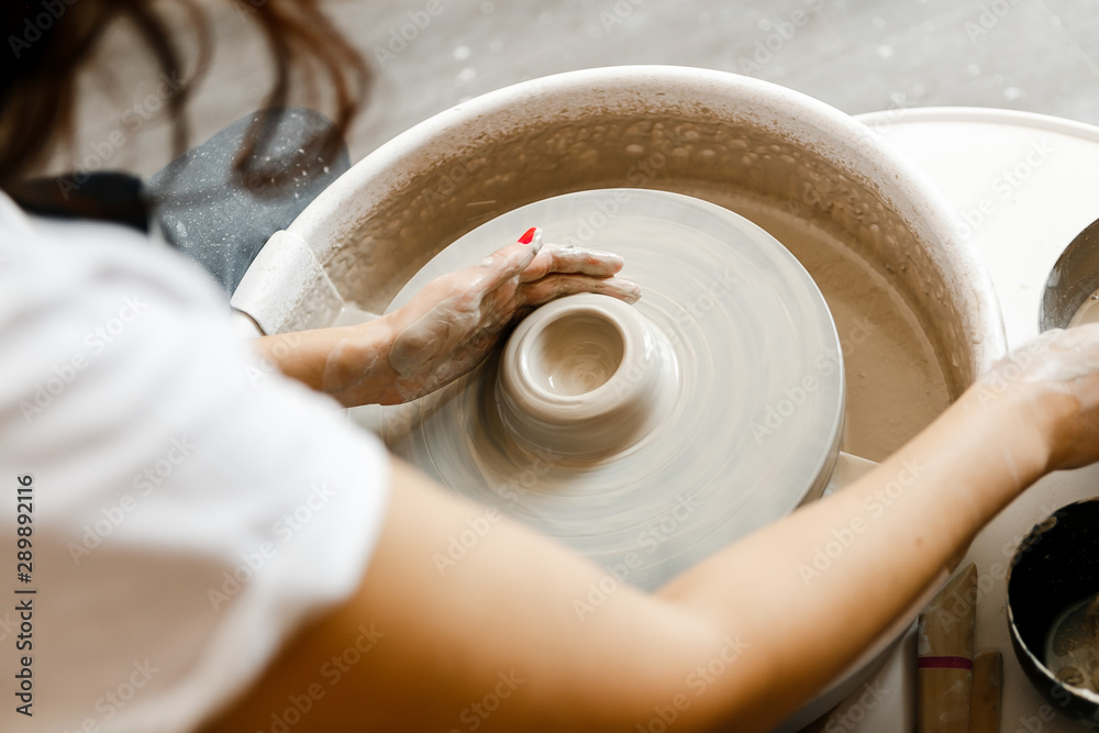 Fototapeta premium girl makes a product on a pottery wheel