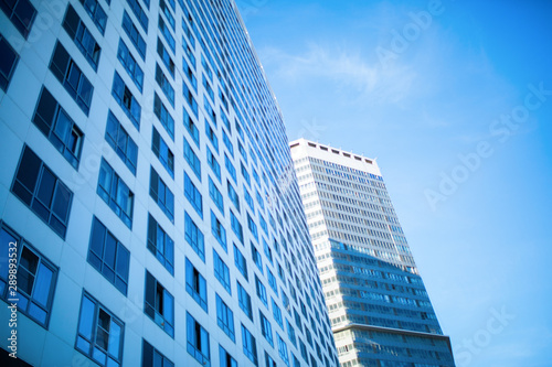 Photo of tall building with glass windows against blue sky