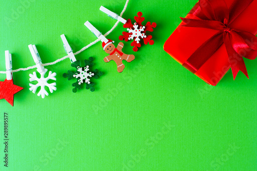Christmas, winter background with copy space. Garland made of decorations snowflakes and red gift box. Flat lay, top view.