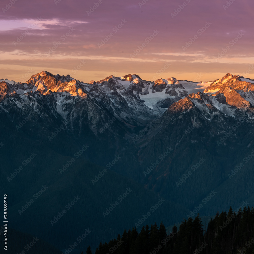 Pink Light from Sunrise Reflects Over Mountain Range