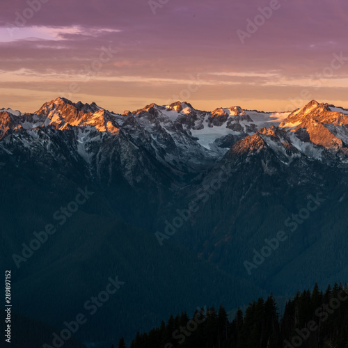 Pink Light from Sunrise Reflects Over Mountain Range