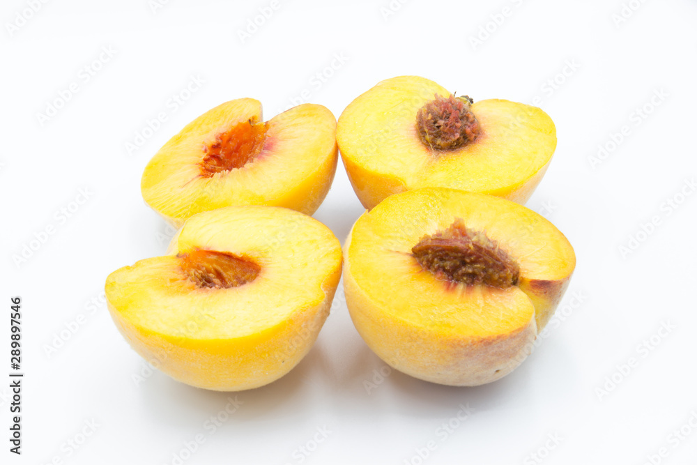 two peaches cut in half with a white background