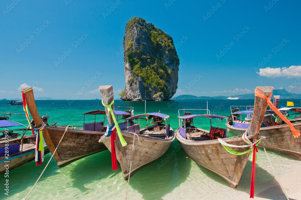 Thai traditional wooden longtail boat and beautiful sand beach at Koh Poda island in Krabi, Thailand. Thai traditional wooden longtail boat and beautiful sand beach at Koh Poda island in Krabi, Thailand.