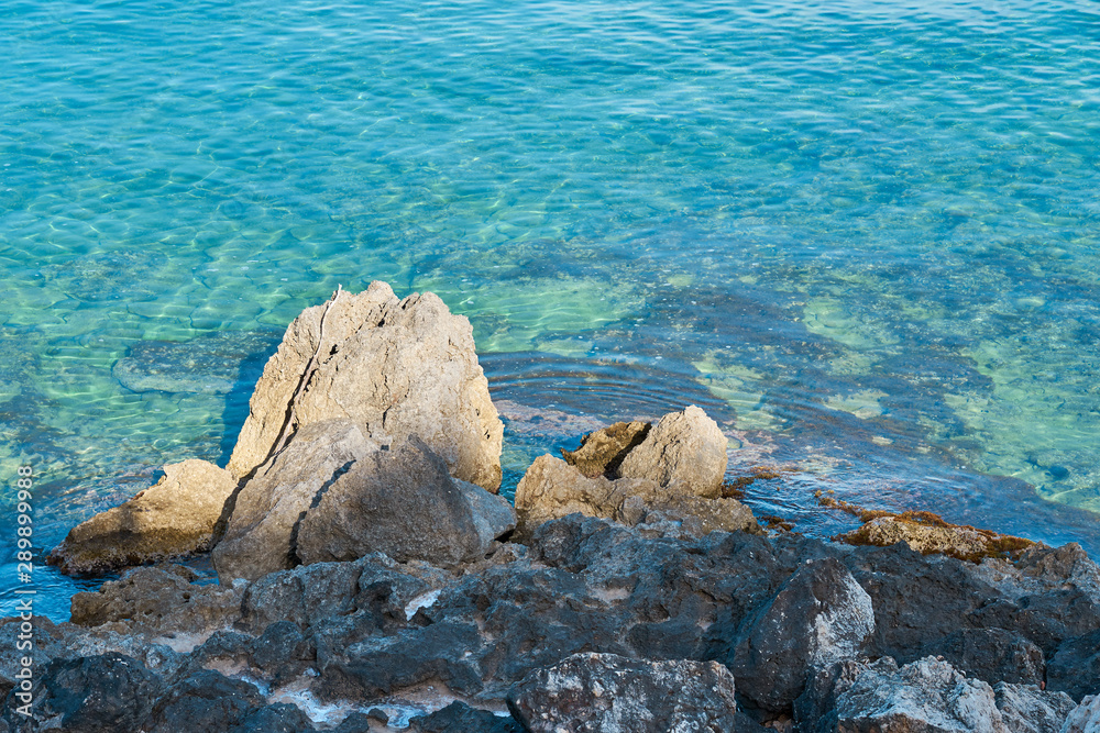 Stones on a sea coast of Colimbari, Crete, Greece against a blue sea water. Copy space. Stones on a sea coast of Colimbari, Crete, Greece against a blue sea water. Copy space.