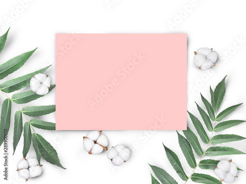 Mock up empty pink paper blank with cotton flowers and leaves isolated on white background. Feminine workplace for blogging concept. Flatlay
