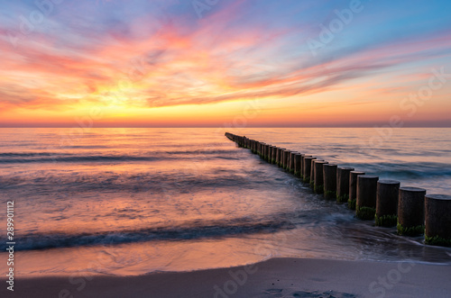 Baltic sea seascape at sunset, Poland, wooden breakwater and waves © tomeyk