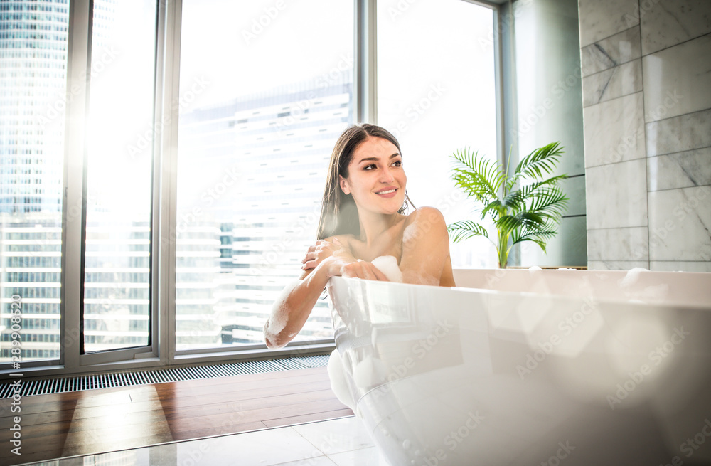 Beautiful woman taking hot bath in a luxury bathroom