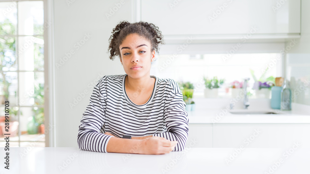 Beautiful african american woman with afro hair wearing casual striped sweater looking sleepy and tired, exhausted for fatigue and hangover, lazy eyes in the morning. Beautiful african american woman with afro hair wearing casual striped sweater looking sleepy and tired, exhausted for fatigue and hangover, lazy eyes in the morning.