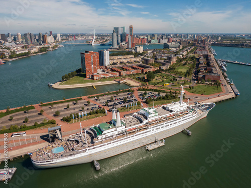 aerial of SS Rotterdam ship moared on Katendrecht land head with skyline of towers and Erasmus bridge in the background 