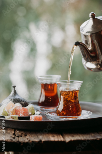 Obraz na płótnie Glass Cup of turkish tea served in traditional style with summer outdore view
