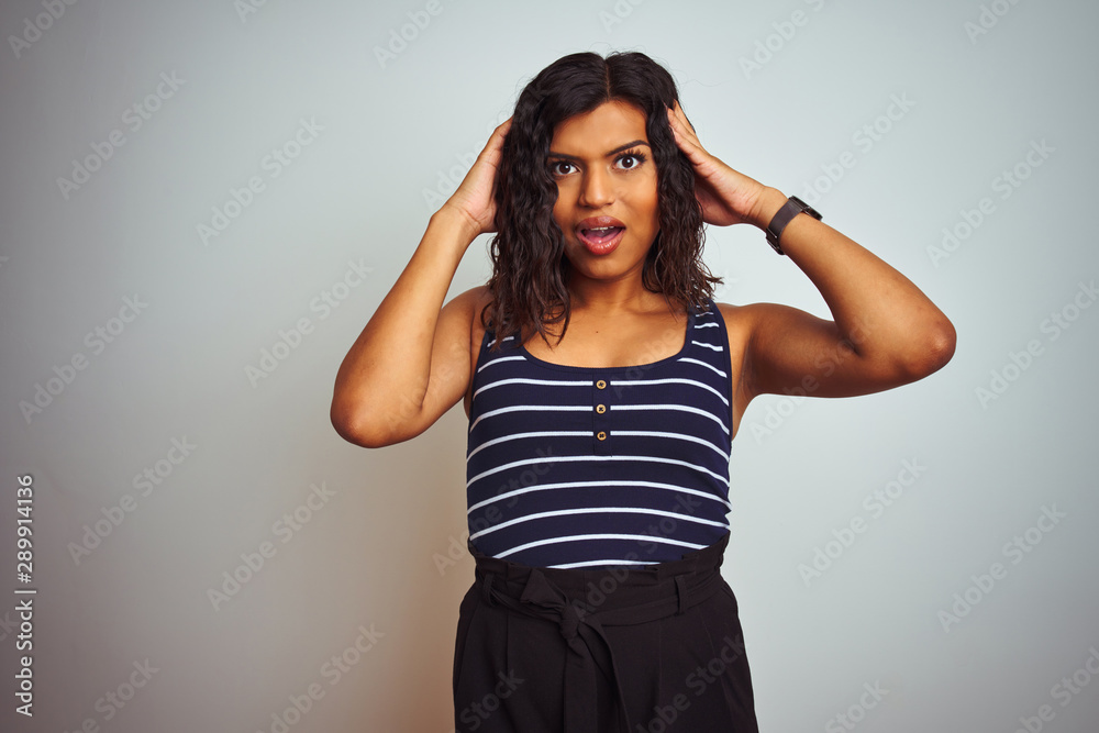 Transsexual transgender woman wearing striped t-shirt over isolated white background Crazy and scared with hands on head, afraid and surprised of shock with open mouth Transsexual transgender woman wearing striped t-shirt over isolated white background Crazy and scared with hands on head, afraid and surprised of shock with open mouth