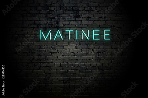 Highlighted brick wall with neon inscription matinee photo