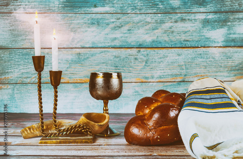 Shabbat eve table candles and cup of wine with covered challah bread, photo