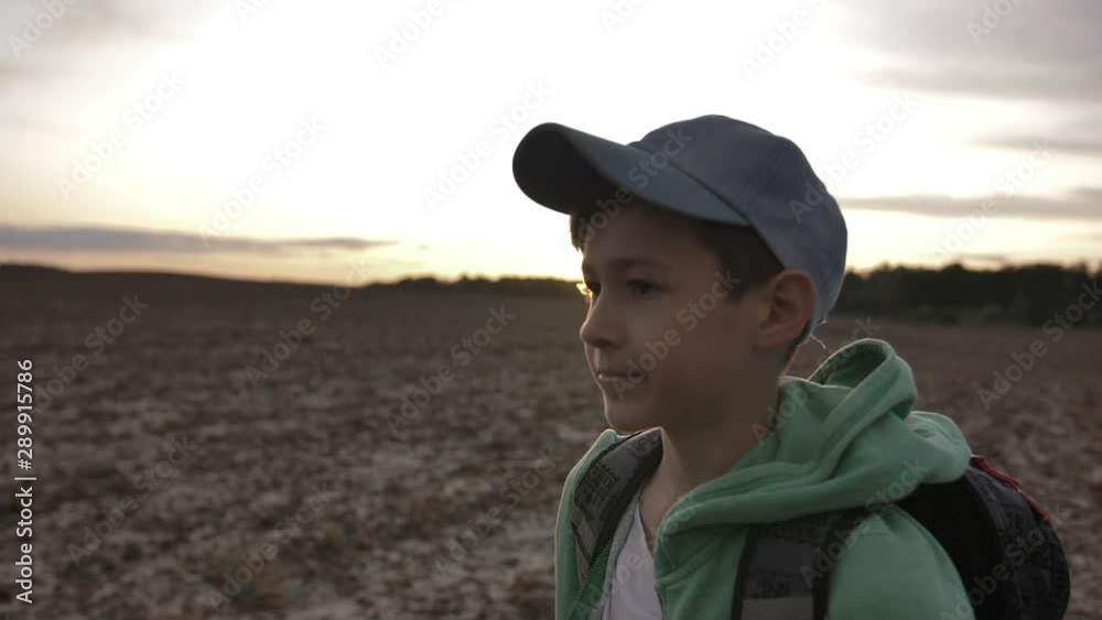 traveling boy with backpack walking at sunset outdoors traveling boy with backpack walking at sunset outdoors