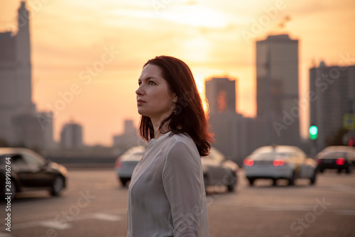 Portrait of a middle-aged woman in profile against the evening city.