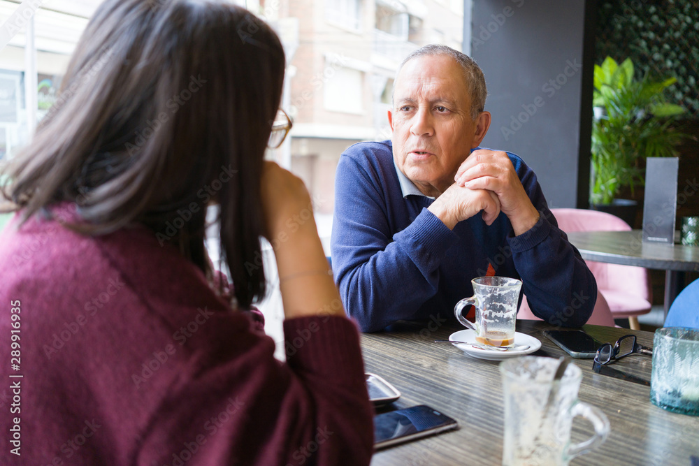 Senior man having a conversation with woman drinking coffee and relaxing, chatting at restaurant Senior man having a conversation with woman drinking coffee and relaxing, chatting at restaurant