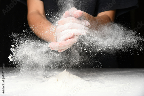 Clap hands of baker with flour