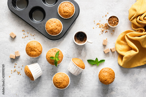 Homemade delicious vegetarian muffins with brown sugar on grey concrete background, flat lay, top view