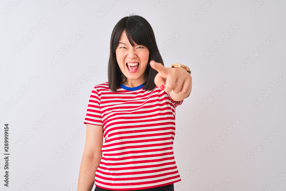 Young beautiful chinese woman wearing red striped t-shirt over isolated white background pointing displeased and frustrated to the camera, angry and furious with you Young beautiful chinese woman wearing red striped t-shirt over isolated white background pointing displeased and frustrated to the camera, angry and furious with you