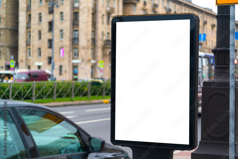 White vertical billboard on the lawn near the road with white mockup background advertising field. standing in the city White vertical billboard on the lawn near the road with white mockup background advertising field. standing in the city