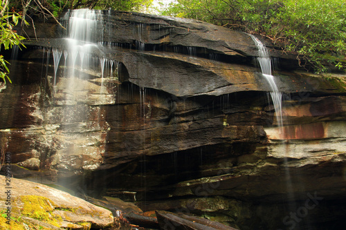 Multiple cascading water falls arcoss rocks terriain in North Carolina photo